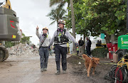 Miami Dade Fire Department crew and a rescue dog at the site of a collapsed Florida condominium complex in Surfside, Miami, US, in this handout image July 2, 2021.