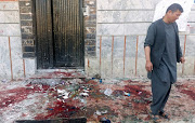 An Afghan man inspects the site of a blast in Kabul, Afghanistan April 22, 2018. 