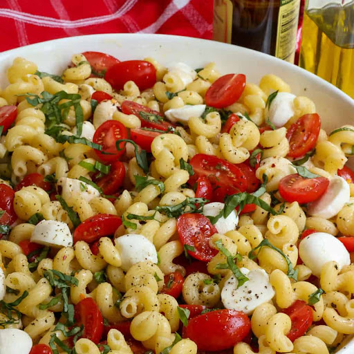 This flavor-packed cold Caprese Pasta Salad brings the best that summer produce has to offer with pasta, tomatoes, mozzarella pearls, and fresh basil together in a tasty garlic balsamic vinaigrette.

