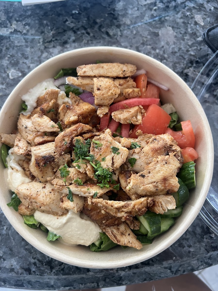 Chicken schwarma bowl no rice, with lettuce as base. Comes with garlic, hummus and veggies