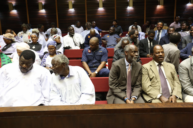 Mduduzi supporters from Ebuhleni on the left appealing the decision that Vela Shembe is the rightful leader of the Shembe church , Vela supporters from the Thembezinhle group are seated in the suits on the Right. The two factions were separated by a cordon tape in the PMB High court for the appeal.