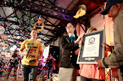 Joanna Brent, the official adjudicator for Guinness World Records, hands over the certificate for the title for the most people eating breakfast in bed.