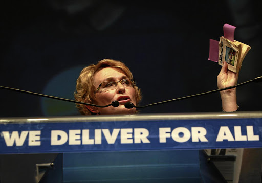 Premier Helen Zille holds up a copy of the South African constitution during a public address.