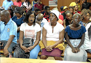 Precious Ramabulana's mother Peggy  (white hat) is supported in court by  Precious' uncle Simon Ramabulana and friend Khulani Mohale (white T-shirt) yesterday./PETER RAMOTHWALA